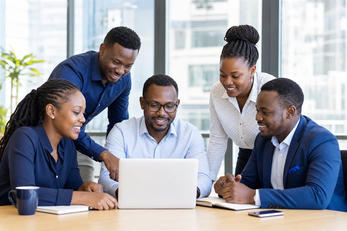 Technology consultants collaborating around a laptop